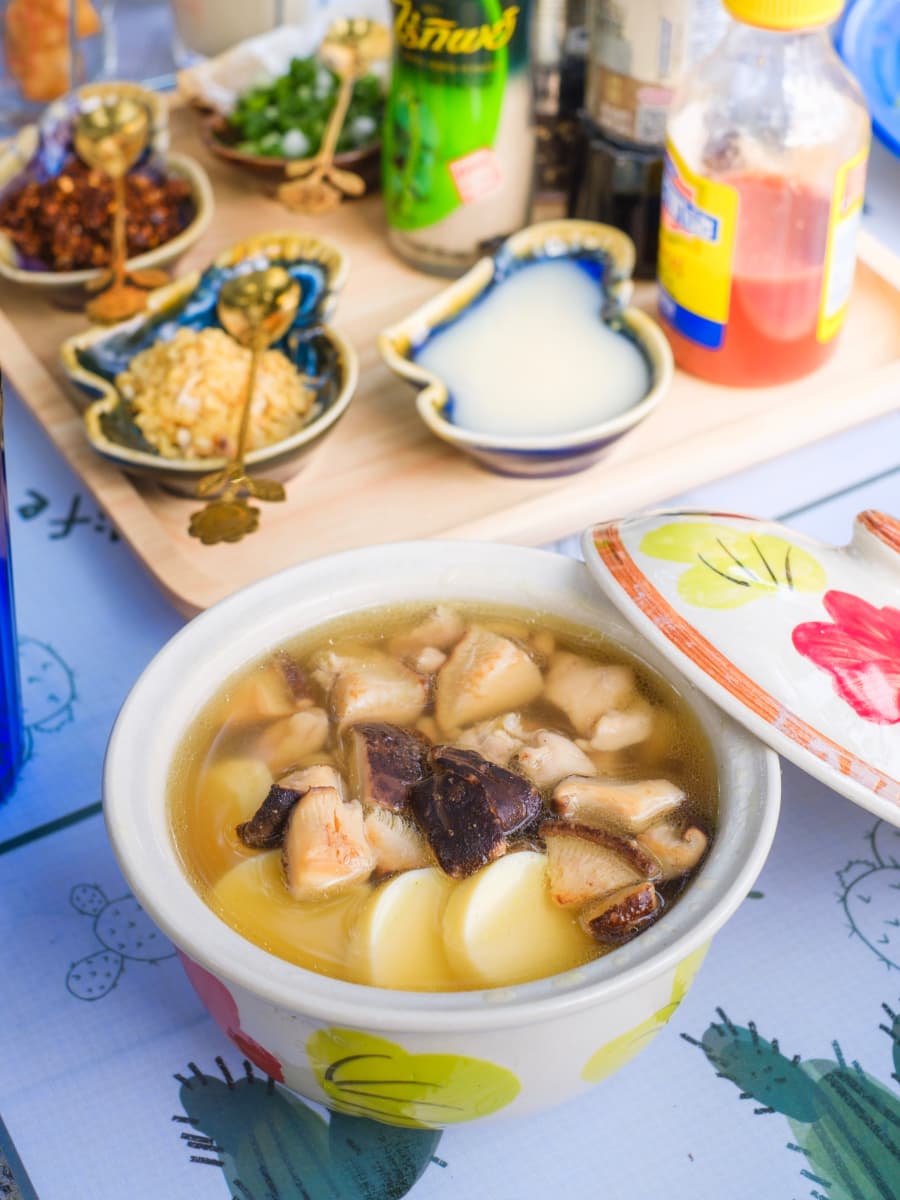 A cozy table set with a bowl chicken of soup