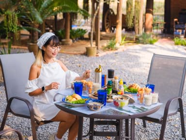 A woman sitting at a table, calmly engaged in her meal