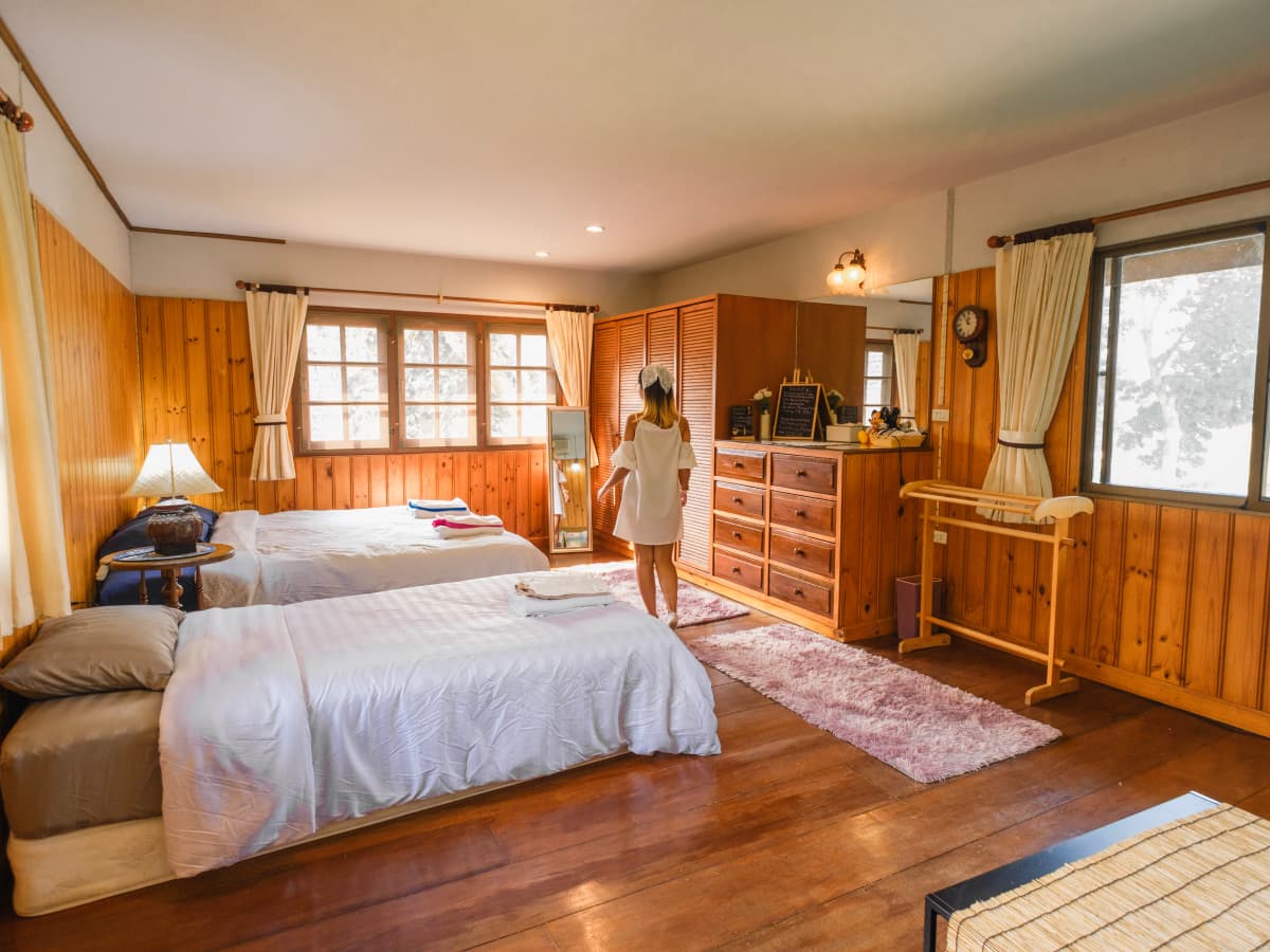 A woman standing in front of a bed