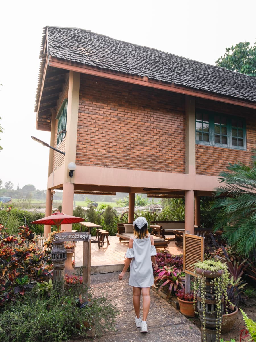 A woman walking through lush greenery on a scenic path