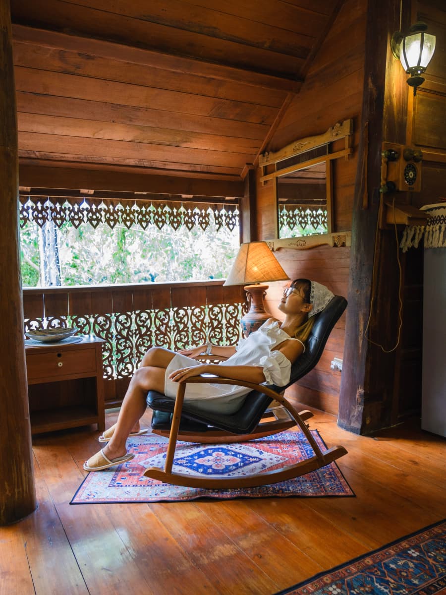 A woman peacefully sits in a rocking chair