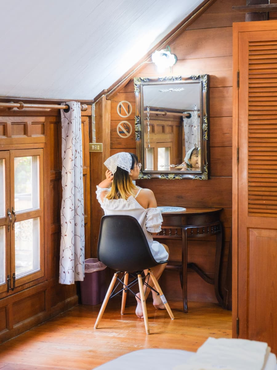 A woman in a sitting in front of a vanity table